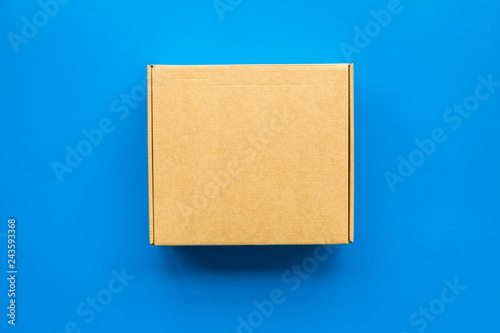 Delivery concept. Cardboard box on blue background top view copy space © 9dreamstudio