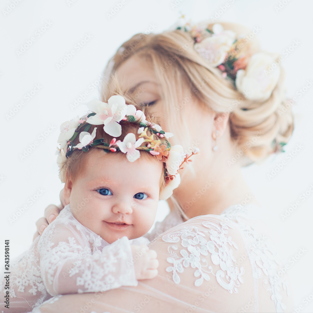 tender portrait of young mother holding infant baby girl, daughter. family look outfit tender portrait of young mother holding infant baby girl, daughter. family look outfit