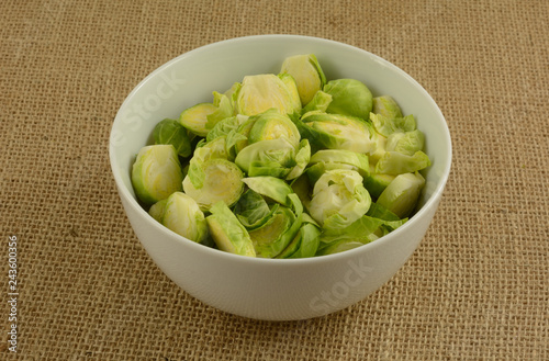 Sliced fresh raw brussel sprouts in white bowl as preparation of ingredient before cooking photo