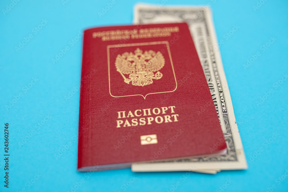 Russian passport with American dollars on the yellow background flat lay