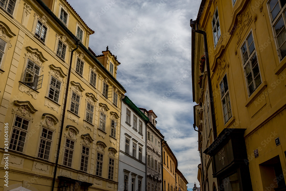 Obraz premium PRAGUE, CZECH REPUBLIC - AUGUST 27, 2015: Light falls in a scenery way upon the beautiful windows of old architecture street in Prague in overcast summer day in the old center of the Czech capital