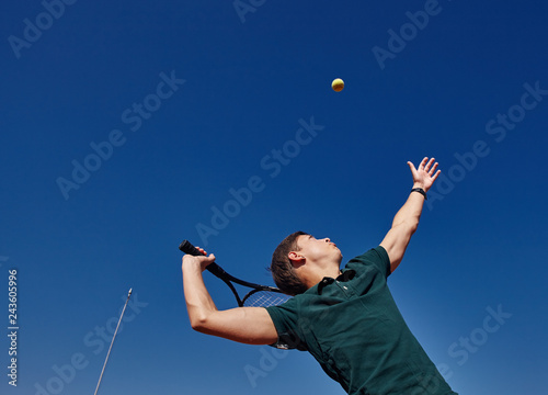 a Man playing tennis on the court on a beautiful sunny day