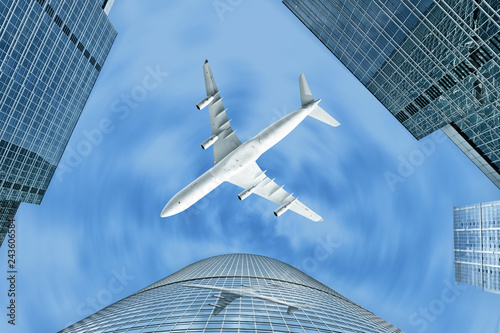 modern city business financial district downtown abstract street overhead view of glass and steel skyscraper building against airplane flying in sky background air travel landscape tower skyline scene