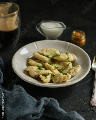 Dumplings in white plate (dough with different fillings). food background. dark background. top