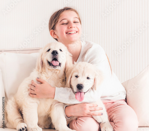 Smiling girl hugging puppies