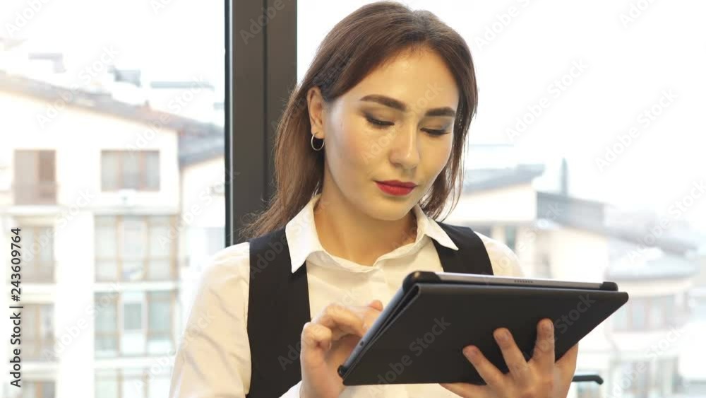 4K. Asian business woman, manager with tablet in office smile in camera. Portrait, steady shot 4K. Asian business woman, manager with tablet in office smile in camera. Portrait, steady shot