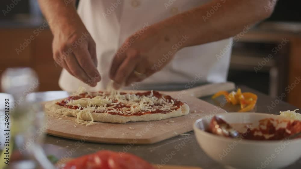 Chef adds mozzarella cheese to pizza