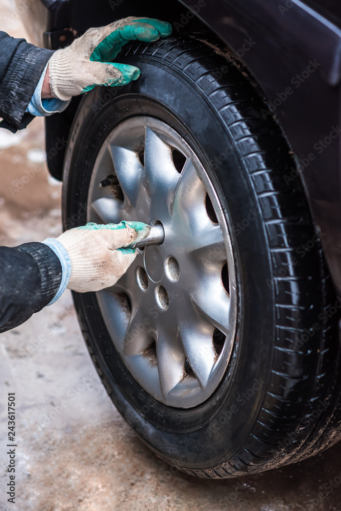 Man's hands unscrews with pneumatic wrench the wheel, changing the tire, repair car Man's hands unscrews with pneumatic wrench the wheel, changing the tire, repair car
