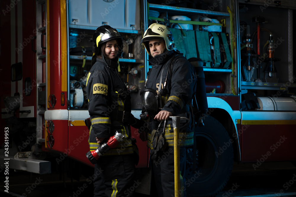 Photo of man and woman firefighter at fire truck