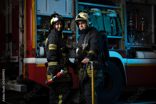 Photo of man and woman firefighter at fire truck