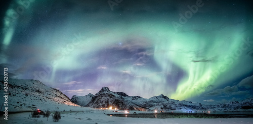 Northern lights explosion on snowy mountain range photo