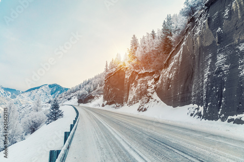 Beautiful winter landscape in the mountains. Winter road in the rocks. Snowy sunrise in the mountains