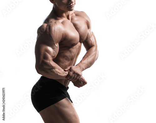 Handsome power athletic man pumping up muscles isolated over white. Strong bodybuilder with perfect shape body and six pack, abs, shoulders, biceps, triceps and chest.