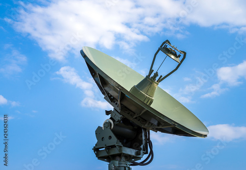 Fototapeta Naklejka Na Ścianę i Meble -  Air defense radar of military mobile rocket launcher system of green color, modern army industry on background clouds and blue sky