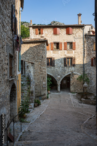 Beautiful stone building with brown shuttered windows in Peille, France