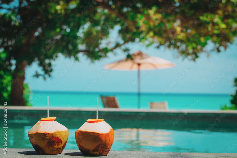 two coconut drinks on tropical beach resort - obrazy, fototapety, plakaty 