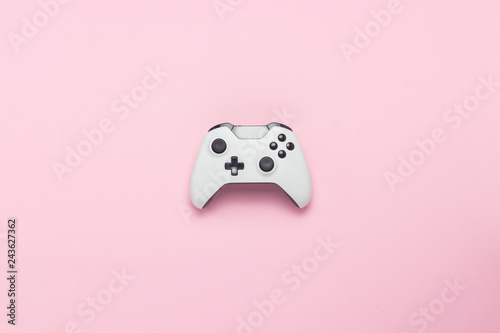 White gamepad on a pink background. Concept game on the console, computer games. Flat lay, top view.