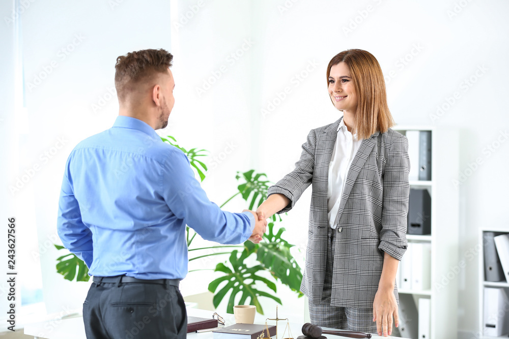 Female lawyer and man shaking hands in office Female lawyer and man shaking hands in office