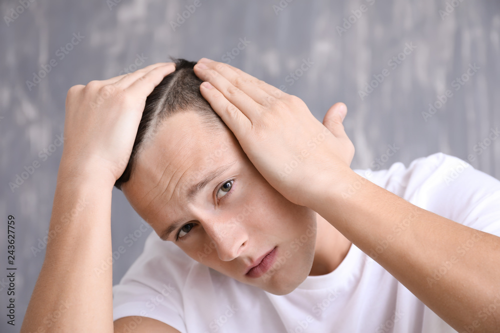 Man with hair loss problem on grey background Man with hair loss problem on grey background