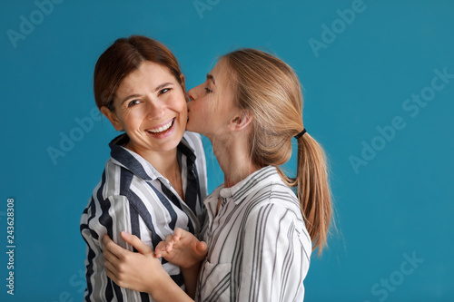 Portrait of happy mother and daughter on color background photo