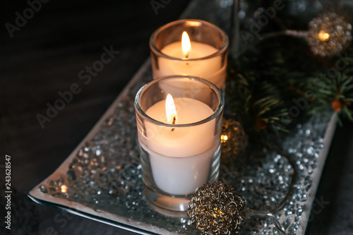 Tray with beautiful burning candles on dark table