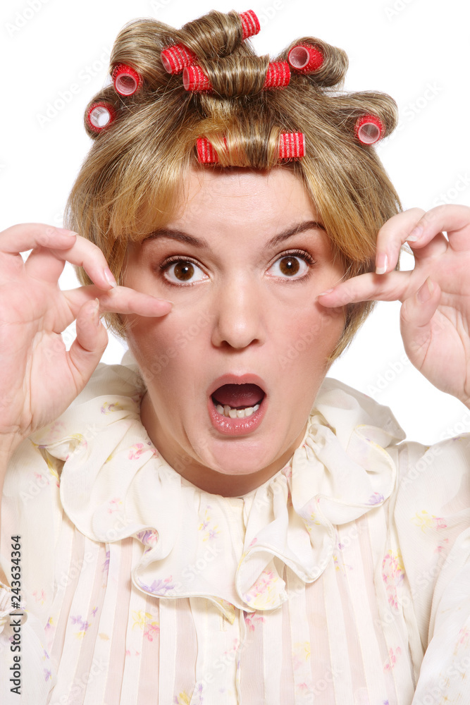 Humorous portrait of old-fashioned grotesque housekeeper with hair curlers and shocked expression Humorous portrait of old-fashioned grotesque housekeeper with hair curlers and shocked expression
