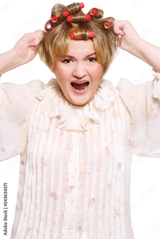 Φωτογραφία Humorous portrait of old-fashioned grotesque housekeeper with hair curlers and f