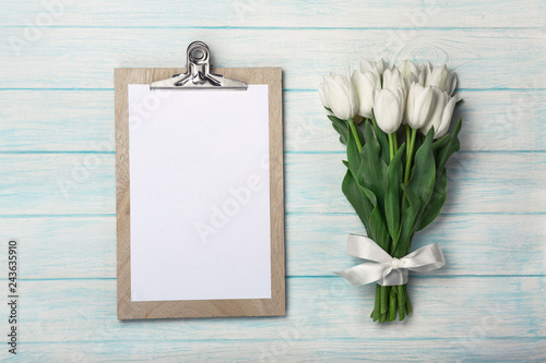 A bouquet of white tulips with tablet on blue wooden boards . Mother's day