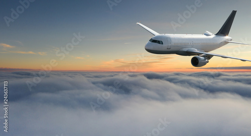Commercial airplane jetliner flying above dramatic clouds.