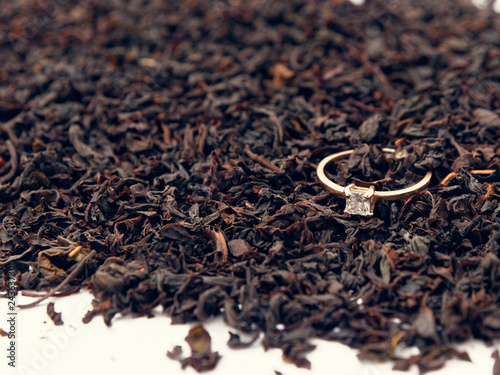 background of black tea leaves. precious ring. decorations.