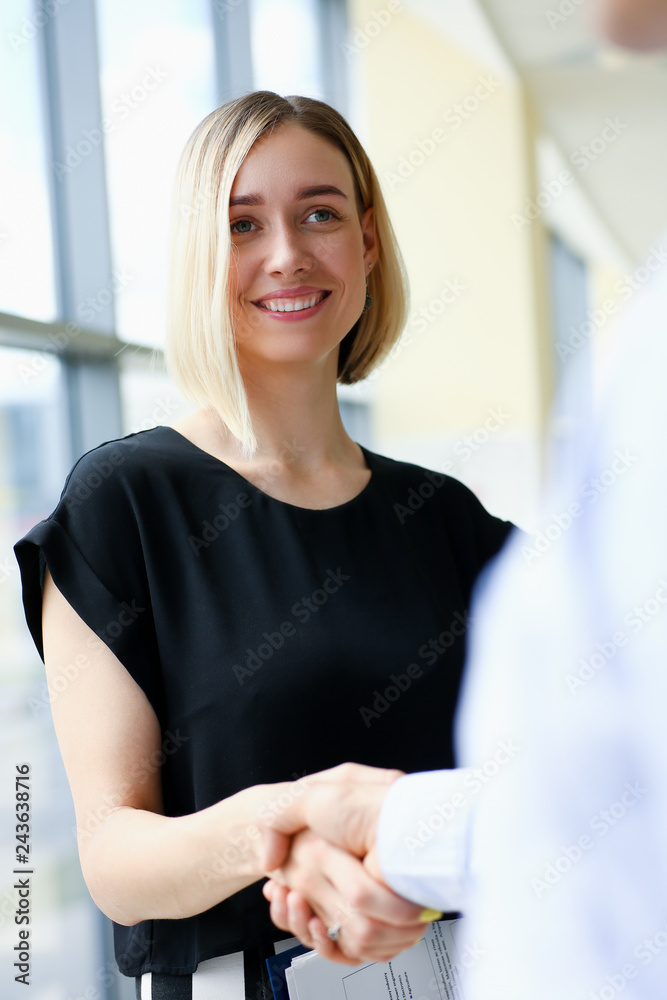 Businessman and woman shake hands as hello