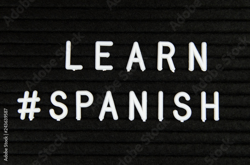 Learn Spanish language, modern looking sign on black background