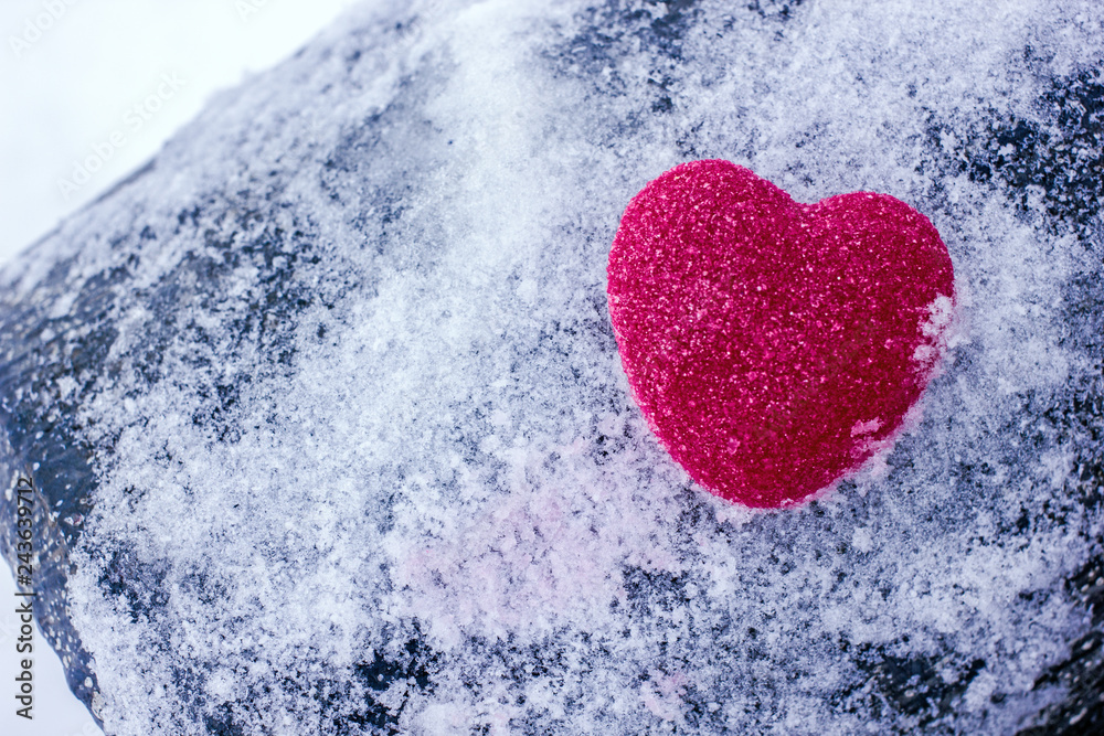 Fototapeta premium Heart in the snow. Valentine's day background with heart.Red heart on white snow, a background about love, a background to the day of lovers, a hot heart in white winter