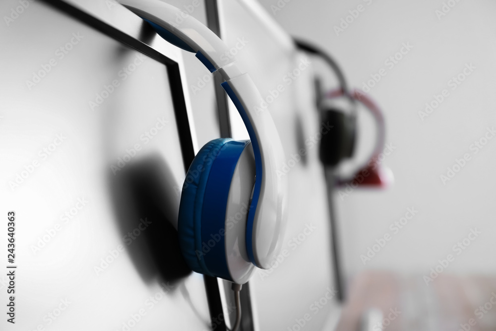 Headphones on PC monitor in computer club, closeup Headphones on PC monitor in computer club, closeup