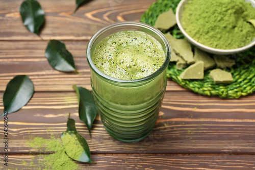 Glass of healthy matcha tea on wooden table