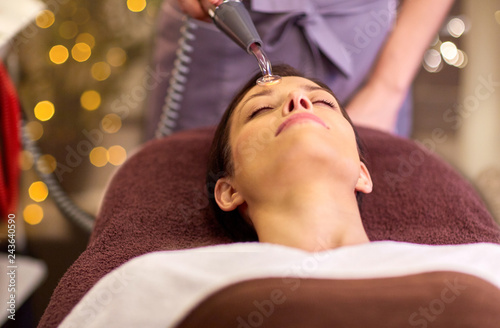 people  beauty  cosmetology and technology concept - beautiful young woman having needle free mesotherapy or hydradermie facial treatment by microcurrent firming device in spa