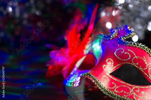 Venetian red mask on defocused carnival party background 