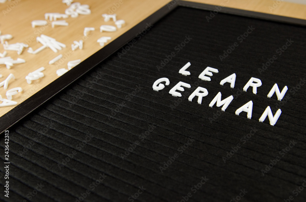 Fototapeta premium Learn German, GER abbreviation, simple sign on black background, great for teachers, schools, students