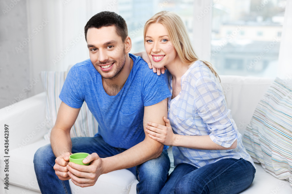 relationships and people concept - happy couple sitting on sofa and hugging at home relationships and people concept - happy couple sitting on sofa and hugging at home