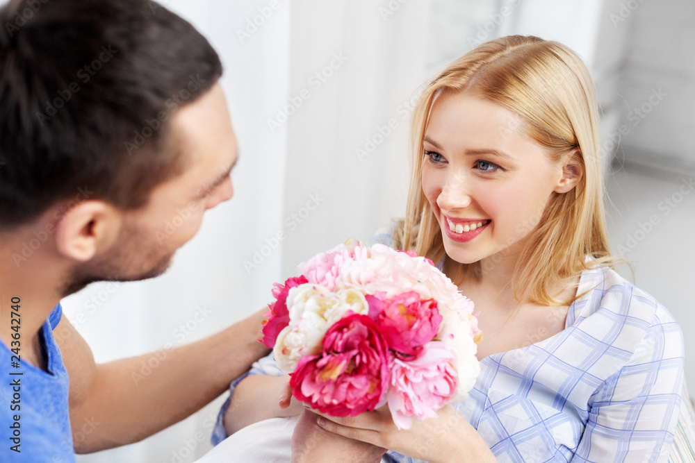 surprise, valentines day and people concept - happy couple with flowers at home surprise, valentines day and people concept - happy couple with flowers at home
