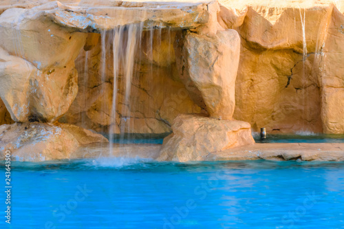 Small waterfall with turquoise water in the hotel pool