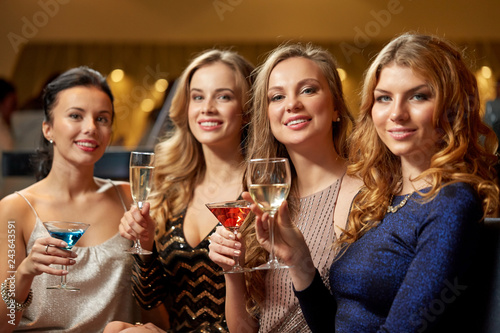 celebration, bachelorette party and holidays concept - happy women or female friends with non-alcoholic drinks in glasses at night club