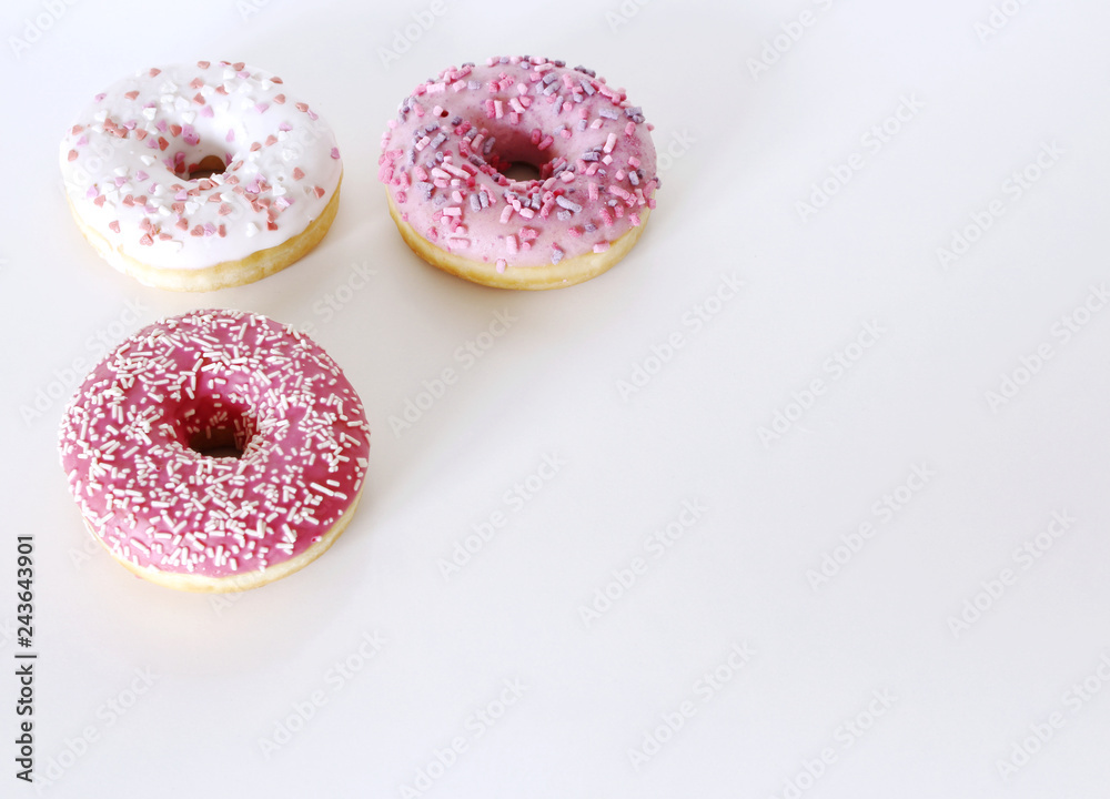 Traditional donuts on white wooden background. Tasty doughnuts with icing and powdered sugar, copy space.