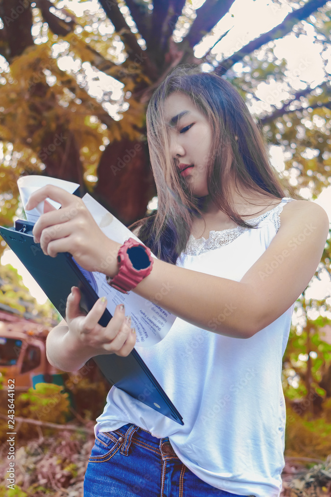 Naklejka premium Female engineer hold chart to check report with nature background.