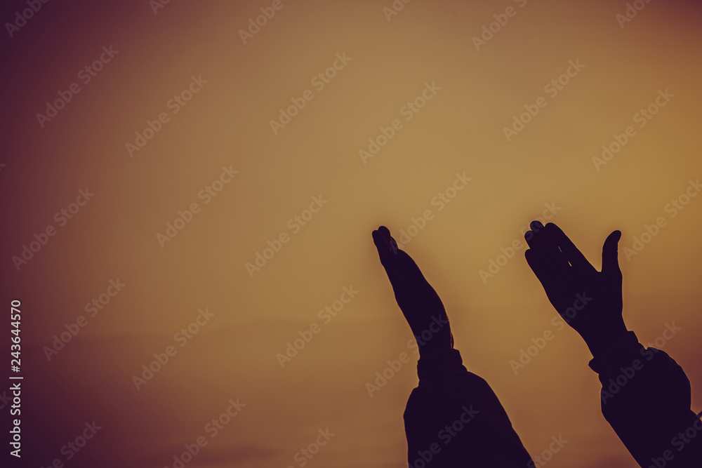 Faith of christian concept: Spiritual prayer hands over sun shine with blurred beautiful sunset background