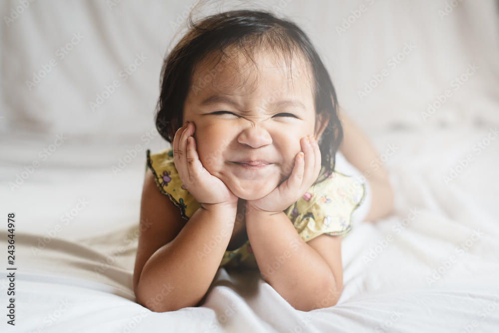 cute little asian girl toddler smiling on bed. concept of happiness, childhood and lifestyle - obrazy, fototapety, plakaty 