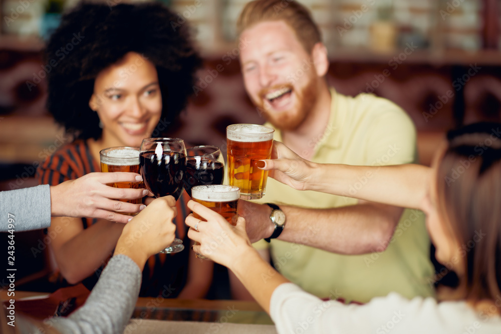 Friends making a toast while sitting in restaurant. Multi-ethnic group. Friends making a toast while sitting in restaurant. Multi-ethnic group.