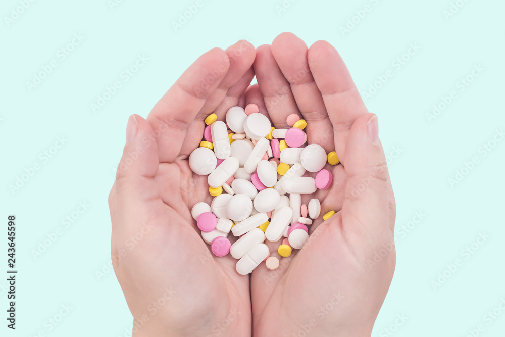 Female hands full of colorful medicines,pills, vitamins or supplements. The concept of a healthy and unhealthy lifestyle Female hands full of colorful medicines,pills, vitamins or supplements. The concept of a healthy and unhealthy lifestyle