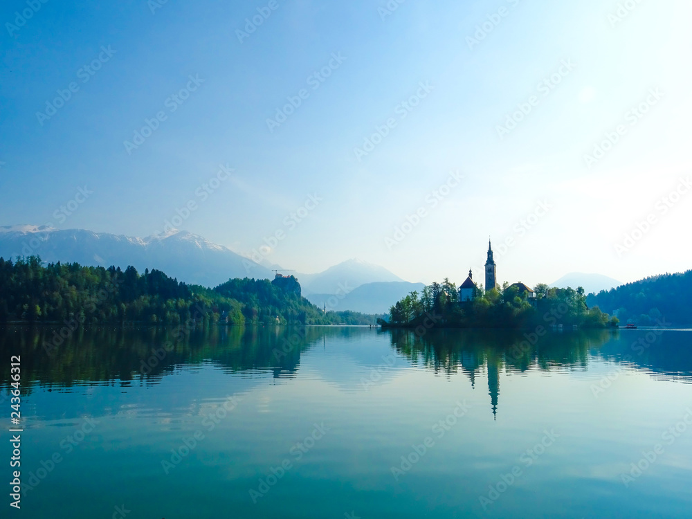 Beautiful panoramic view from the lake to a small island with a church and mountains Beautiful panoramic view from the lake to a small island with a church and mountains