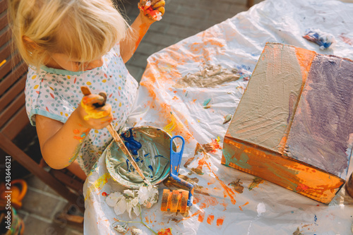 Photo Little girl painting a outside in the garden